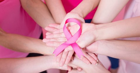 women show pink ribbon with breast cancer prevention on the pink background